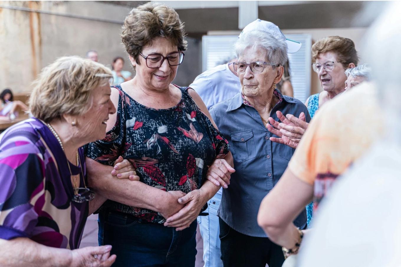Mujeres mayores conversando y compartiendo un momento en un encuentro comunitario