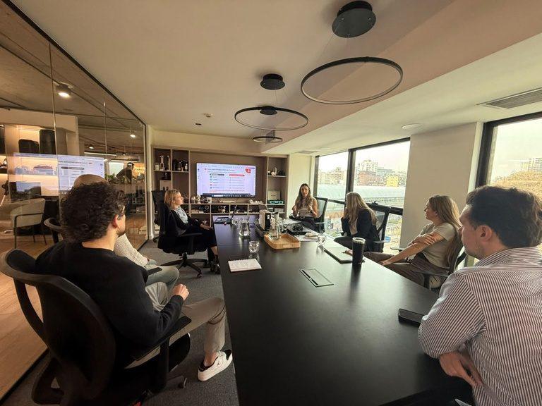 Equipo de trabajo reunido, analizando información en una sala de reuniones